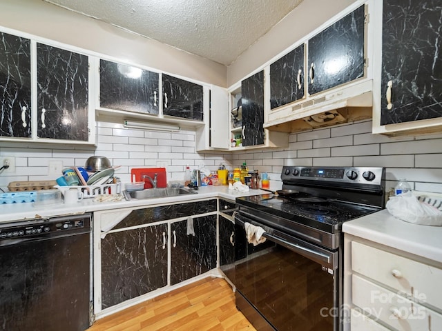 7977 Shady Oak Trl, Charlotte, NC 28210 - kitchen featuring black appliances, under cabinet range hood, a sink, light wood finished floors, and a textured ceiling
