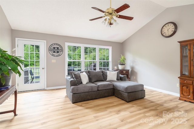 living room featuring a ceiling fan, light wood-style floors, baseboards, and high vaulted ceiling