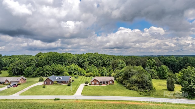 aerial view of property and surrounding area with a heavily wooded area