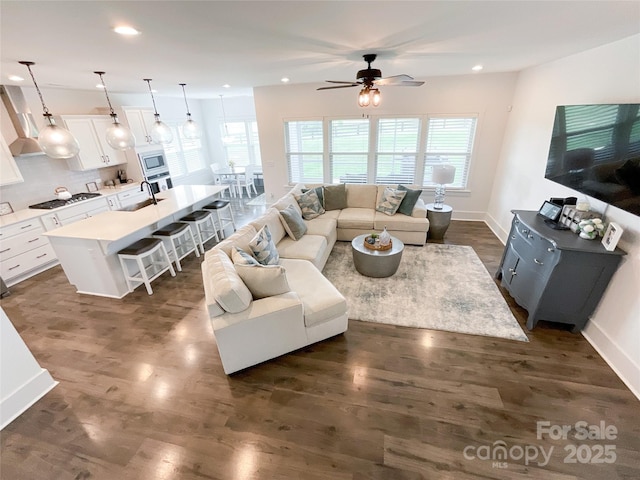 living room with a ceiling fan, recessed lighting, baseboards, and dark wood finished floors