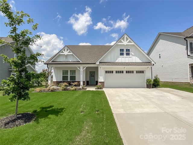 craftsman-style home featuring board and batten siding, roof with shingles, an attached garage, a front yard, and concrete driveway