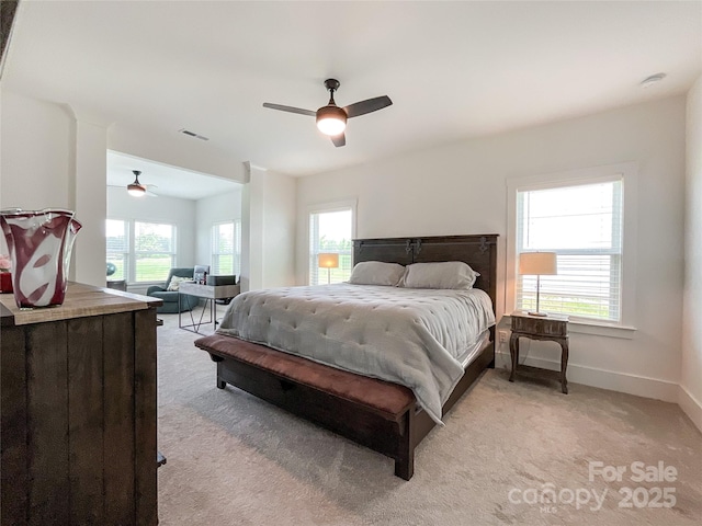 bedroom with light colored carpet, baseboards, and a ceiling fan