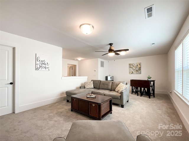 living room with light colored carpet, ceiling fan, and baseboards