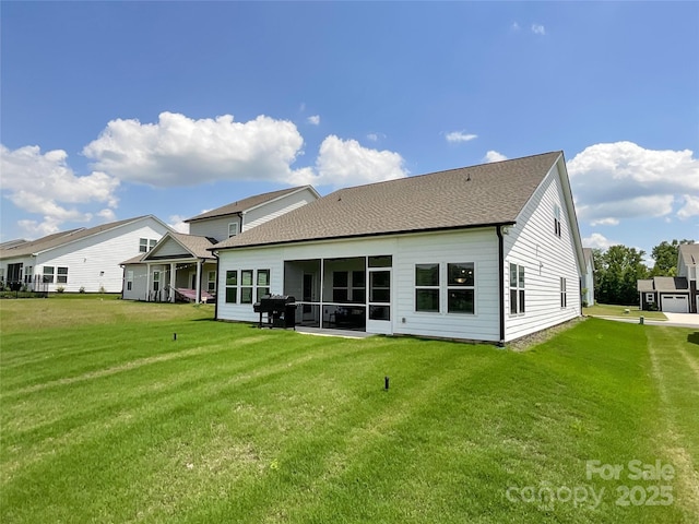 rear view of property featuring a yard and a shingled roof