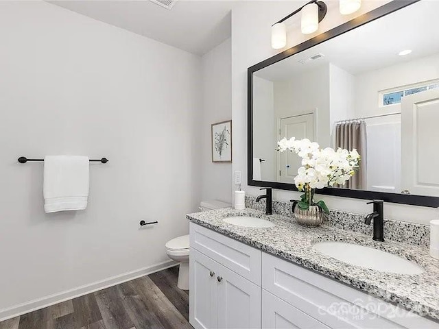 1604 N Main St, Mount Holly, NC 28120 - bathroom featuring toilet, wood finished floors, double vanity, and baseboards