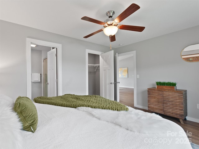 128 Lewis Ln, Candler, NC 28715 - bedroom featuring wood finished floors, baseboards, a closet, a ceiling fan, and an AC wall unit