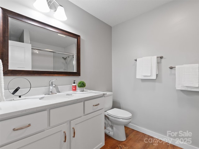 128 Lewis Ln, Candler, NC 28715 - full bathroom featuring vanity, toilet, wood finished floors, a shower, and baseboards