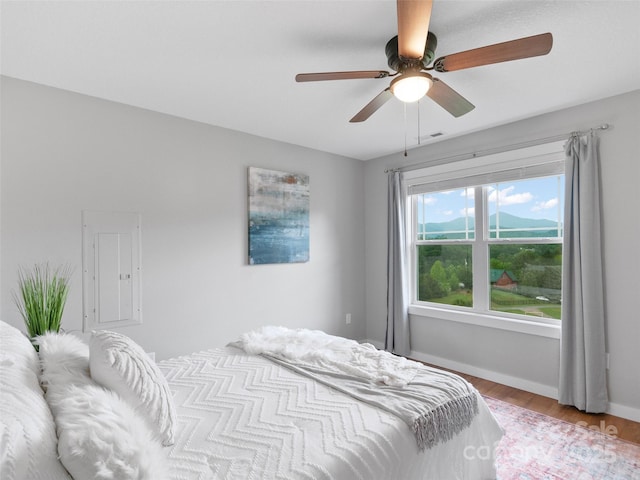 128 Lewis Ln, Candler, NC 28715 - bedroom with electric panel, wood finished floors, baseboards, and ceiling fan
