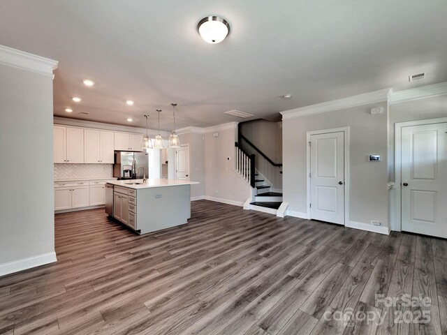 2001 Laurel Village Cir, Belmont, NC 28012 - kitchen with crown molding, recessed lighting, stainless steel refrigerator with ice dispenser, light countertops, and an island with sink