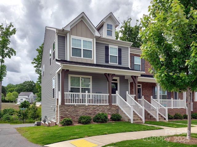 2001 Laurel Village Cir, Belmont, NC 28012 - view of front of home with covered porch, a front yard, board and batten siding, and central AC