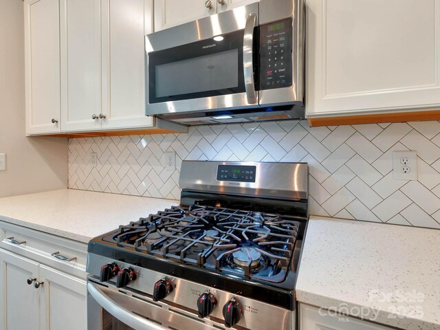 2001 Laurel Village Cir, Belmont, NC 28012 - kitchen with stainless steel appliances, backsplash, white cabinetry, and light stone counters