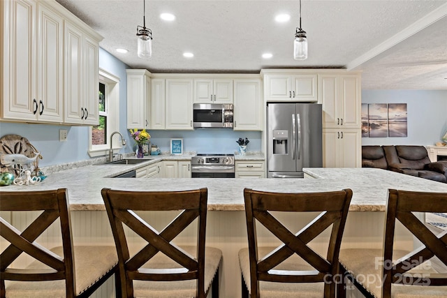 174 Sassafras Hill Dr Unit 41, Rutherfordton, NC 28139 - kitchen featuring stainless steel appliances, a sink, a textured ceiling, a kitchen bar, and decorative light fixtures