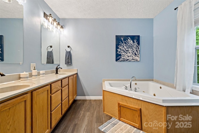 174 Sassafras Hill Dr Unit 41, Rutherfordton, NC 28139 - bathroom featuring a textured ceiling, wood finished floors, baseboards, a tub with jets, and double vanity
