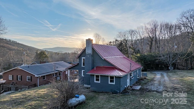 40 Painter Rd, Banner Elk, NC 28604 - property exterior at dusk featuring a chimney, metal roof, and a mountain view