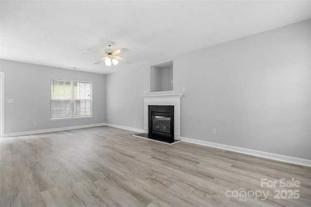 4004 Shasta Cir, Clover, SC 29710 - unfurnished living room featuring light wood-style flooring, a ceiling fan, a glass covered fireplace, and baseboards