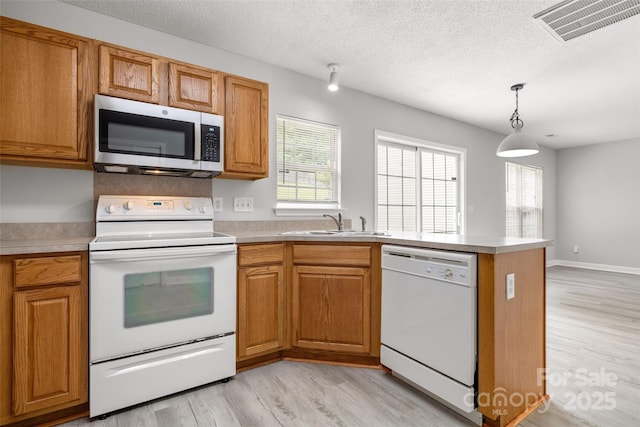 4004 Shasta Cir, Clover, SC 29710 - kitchen with white appliances, light wood finished floors, a peninsula, healthy amount of natural light, and a textured ceiling