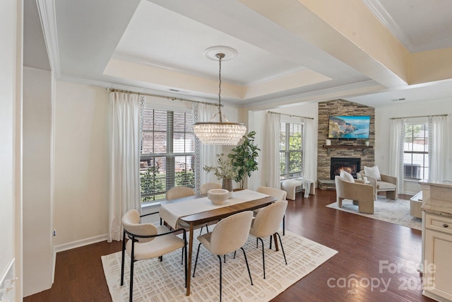 4028 Woodsmill Rd, Fort Mill, SC 29707 - dining area with healthy amount of natural light, dark wood finished floors, a stone fireplace, a raised ceiling, and ornamental molding