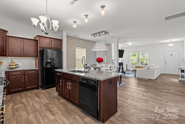 9132 Colwick Hill Ln, Charlotte, NC 28215 - kitchen with black appliances, a sink, open floor plan, and wood finished floors