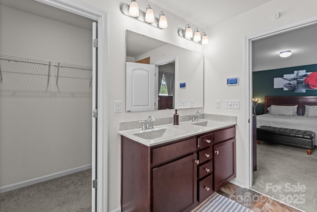 9132 Colwick Hill Ln, Charlotte, NC 28215 - bathroom featuring double vanity, a walk in closet, and baseboards