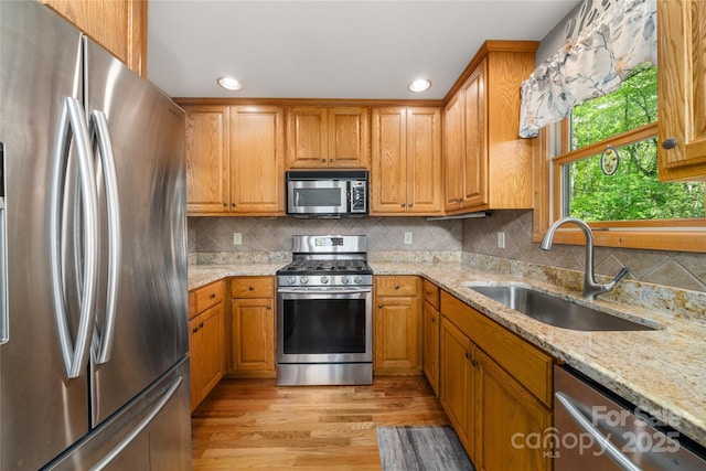 332 Mystic Cv, Waynesville, NC 28785 - kitchen featuring appliances with stainless steel finishes, light wood-style floors, light stone counters, recessed lighting, and brown cabinets