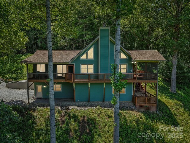 332 Mystic Cv, Waynesville, NC 28785 - rear view of house featuring a chimney, stairs, a wooden deck, a shingled roof, and a wooded view