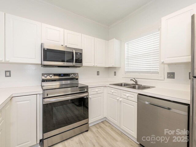 8747 Coralbell Ln, Charlotte, NC 28213 - kitchen featuring stainless steel appliances, a sink, ornamental molding, white cabinets, and light countertops