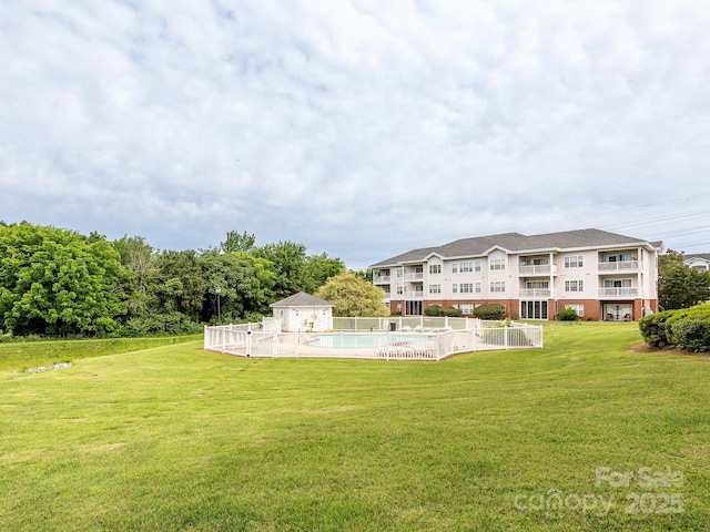 8747 Coralbell Ln, Charlotte, NC 28213 - back of property featuring a community pool, brick siding, an outbuilding, and a patio