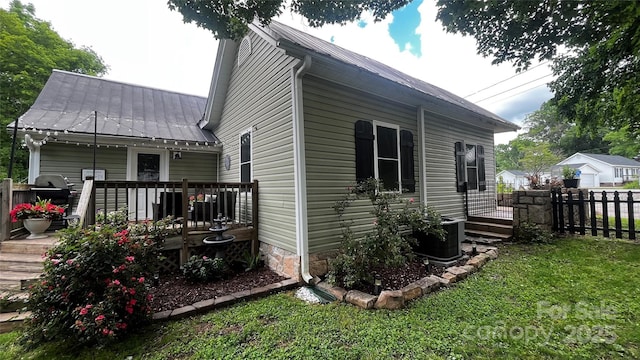 view of side of home with a deck and metal roof