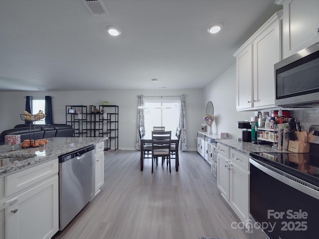 3322 Brighton Dr, Gastonia, NC 28052 - kitchen with appliances with stainless steel finishes, white cabinetry, light wood finished floors, light stone counters, and recessed lighting