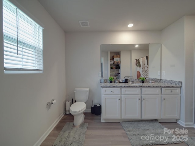 3322 Brighton Dr, Gastonia, NC 28052 - bathroom with wood finished floors, vanity, toilet, baseboards, and recessed lighting