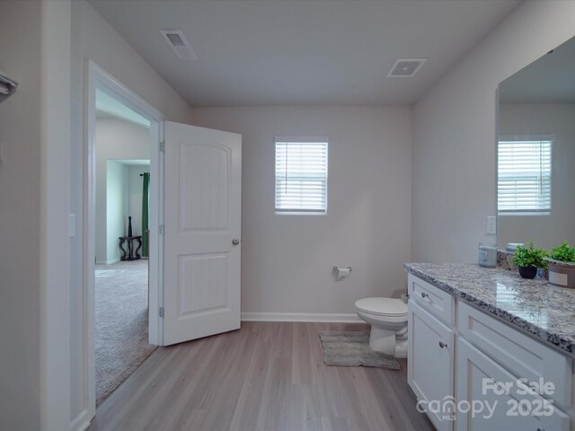 3322 Brighton Dr, Gastonia, NC 28052 - half bathroom with wood finished floors, vanity, toilet, and baseboards
