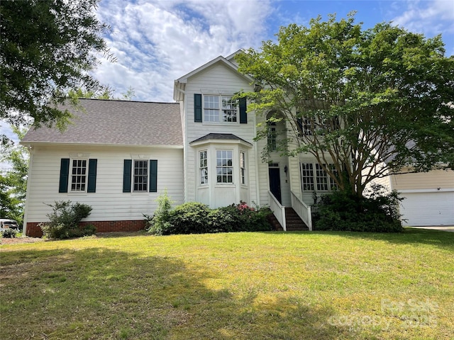 traditional-style house featuring a front yard and a shingled roof