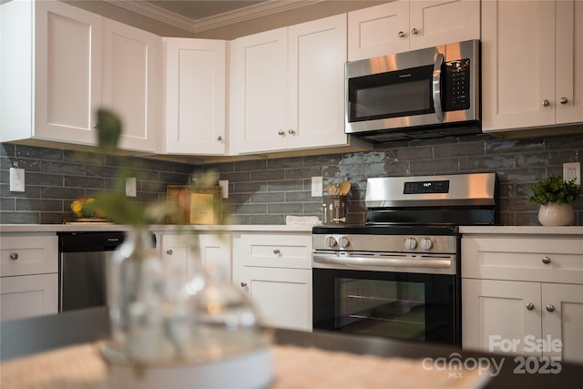 62 Leisure Ln, Maggie Valley, NC 28751 - kitchen with appliances with stainless steel finishes, ornamental molding, light countertops, white cabinetry, and backsplash
