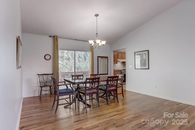 703 Cinnamon Way, Flat Rock, NC 28731 - dining space with light wood-style flooring, a chandelier, vaulted ceiling, and baseboards