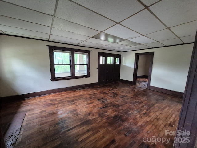 foyer entrance featuring a paneled ceiling, baseboards, and dark wood-style floors