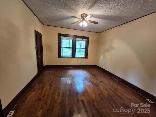 empty room with dark wood-type flooring, a textured ceiling, ceiling fan, and baseboards