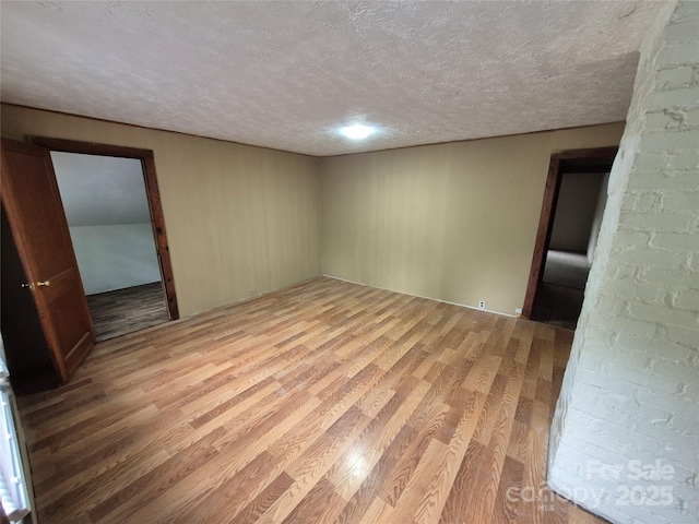 spare room with a textured ceiling and light wood-style floors