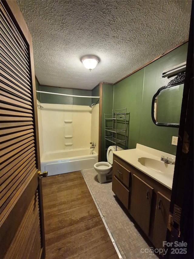 full bathroom featuring wood finished floors, vanity, toilet, and bathtub / shower combination