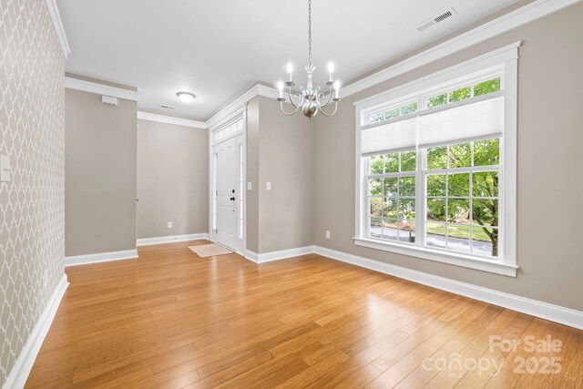 132 E Morehouse Ave, Mooresville, NC 28117 - unfurnished room with crown molding, a chandelier, baseboards, and light wood-style flooring