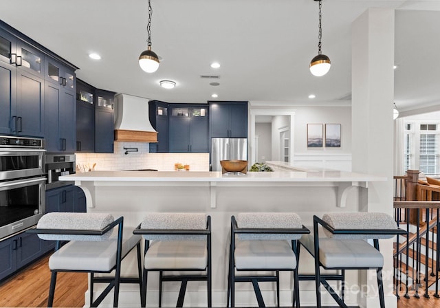 434 Breezewood Dr, Belmont, NC 28012 - kitchen with custom exhaust hood, appliances with stainless steel finishes, light countertops, tasteful backsplash, and hanging light fixtures