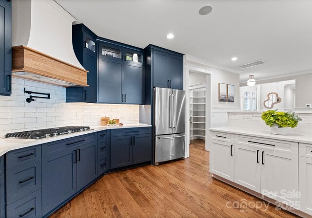 434 Breezewood Dr, Belmont, NC 28012 - kitchen with appliances with stainless steel finishes, premium range hood, glass insert cabinets, light countertops, and light wood-style flooring