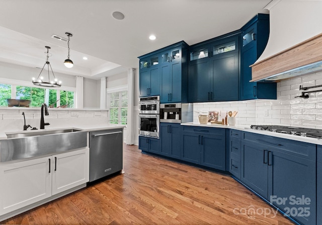 434 Breezewood Dr, Belmont, NC 28012 - kitchen featuring stainless steel appliances, premium range hood, blue cabinets, decorative backsplash, and recessed lighting