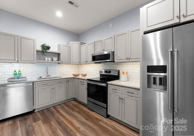 434 Breezewood Dr, Belmont, NC 28012 - kitchen with stainless steel appliances, gray cabinetry, dark wood-style flooring, open shelves, and light stone countertops