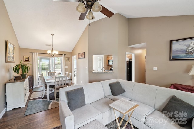 living room featuring ceiling fan, dark wood finished floors, a chandelier, high vaulted ceiling, and baseboards