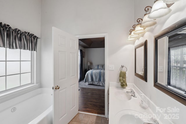 ensuite bathroom with a bath, tile patterned floors, and double vanity