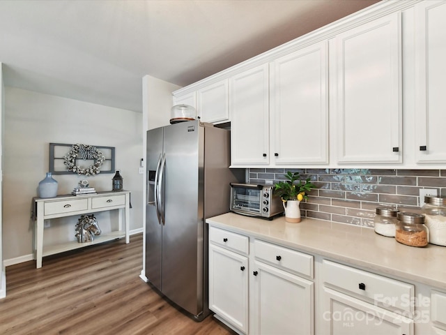 2005 Grimley Ln, Fort Mill, SC 29707 - kitchen with stainless steel fridge, white cabinets, backsplash, wood finished floors, and light countertops