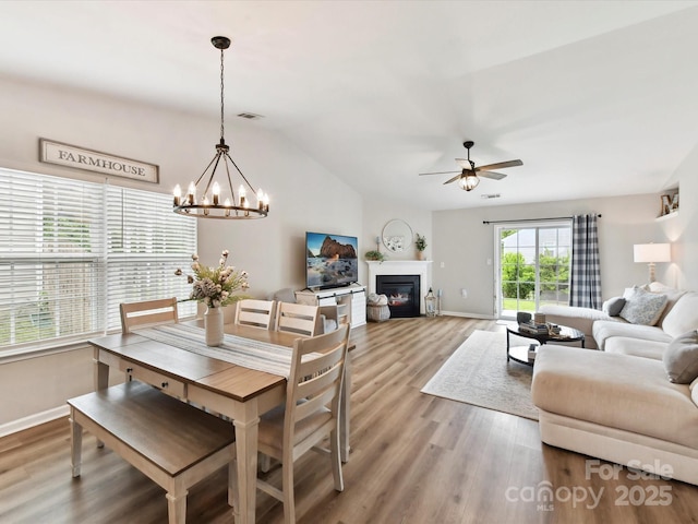 2005 Grimley Ln, Fort Mill, SC 29707 - dining area featuring baseboards, ceiling fan, wood finished floors, vaulted ceiling, and a glass covered fireplace