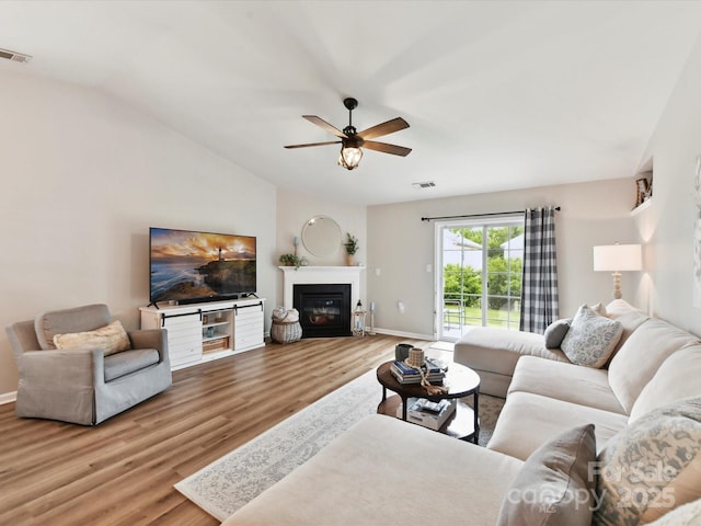 2005 Grimley Ln, Fort Mill, SC 29707 - living area with wood finished floors, baseboards, a ceiling fan, vaulted ceiling, and a glass covered fireplace