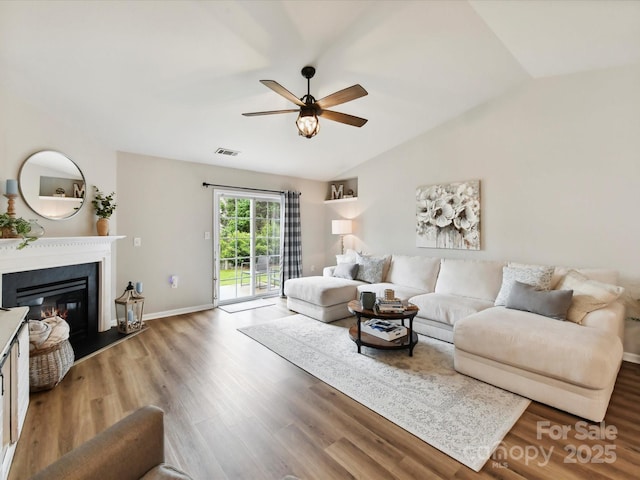 2005 Grimley Ln, Fort Mill, SC 29707 - living room with a ceiling fan, wood finished floors, a glass covered fireplace, vaulted ceiling, and baseboards