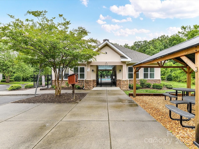 2005 Grimley Ln, Fort Mill, SC 29707 - view of front of home with a gate, stone siding, and stucco siding